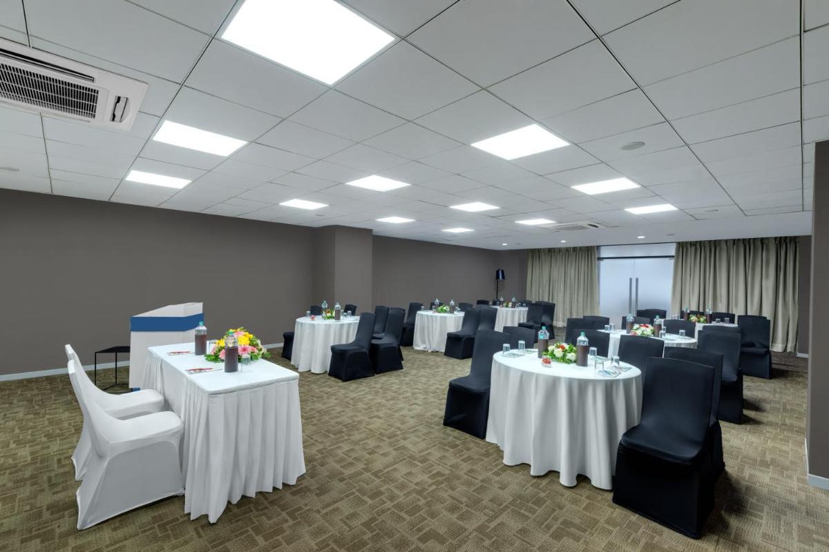 a conference room with white tables and blue chairs at Wyndham Ahmedabad Shela in Ahmedabad