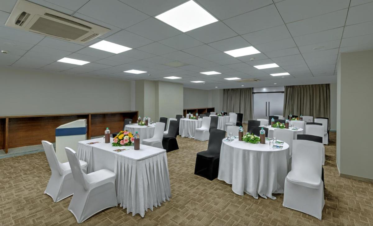 a conference room with white tables and white chairs at Wyndham Ahmedabad Shela in Ahmedabad