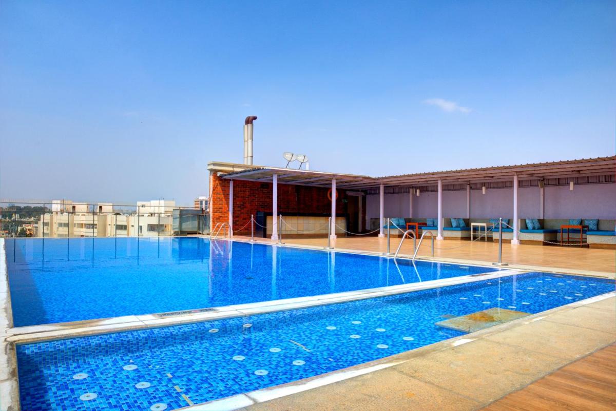 a large swimming pool on top of a building at Hotel Royal Orchid Bangalore in Bengaluru