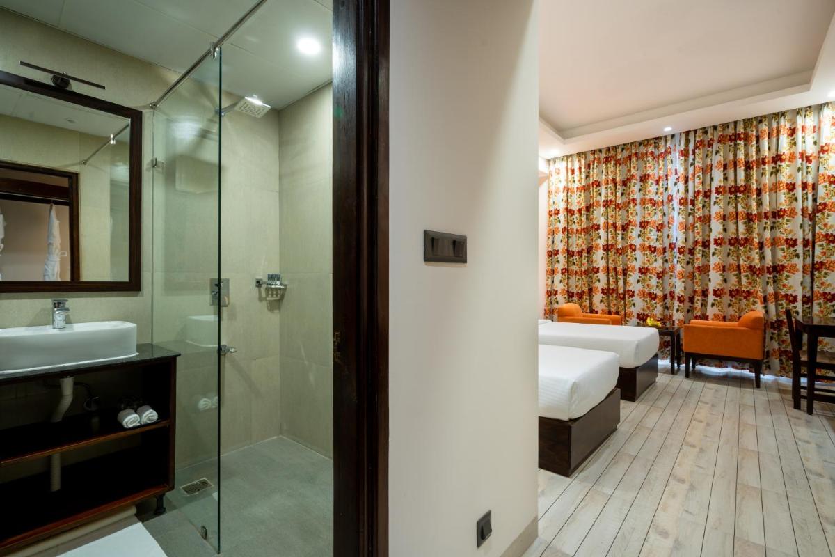 a bathroom with a bed and a sink and a shower at The Orchid Shimla in Shimla