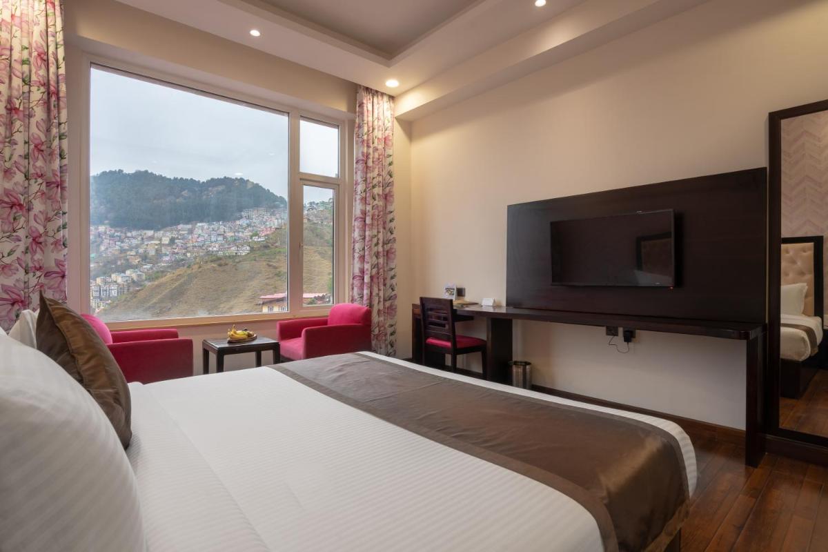 a hotel room with a bed and a large window at The Orchid Shimla in Shimla +107 photos