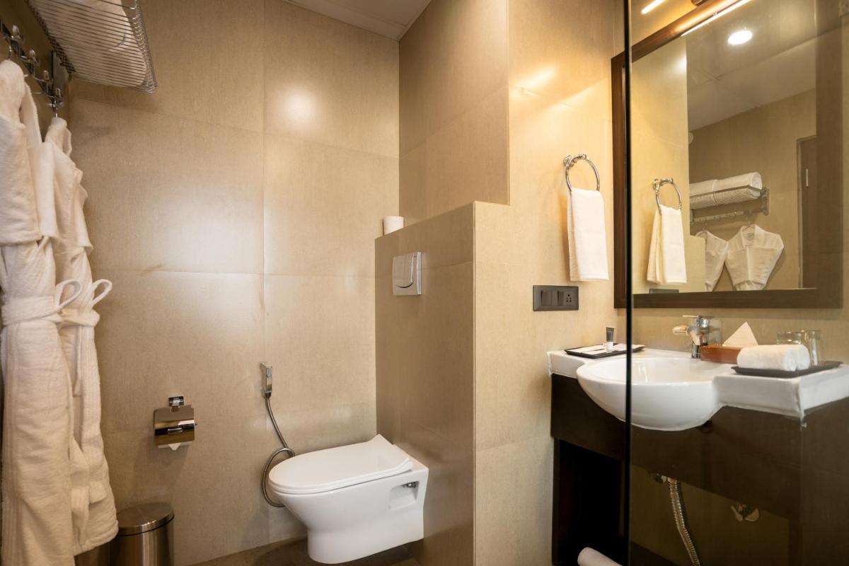 a bathroom with a toilet and a sink at The Orchid Shimla in Shimla