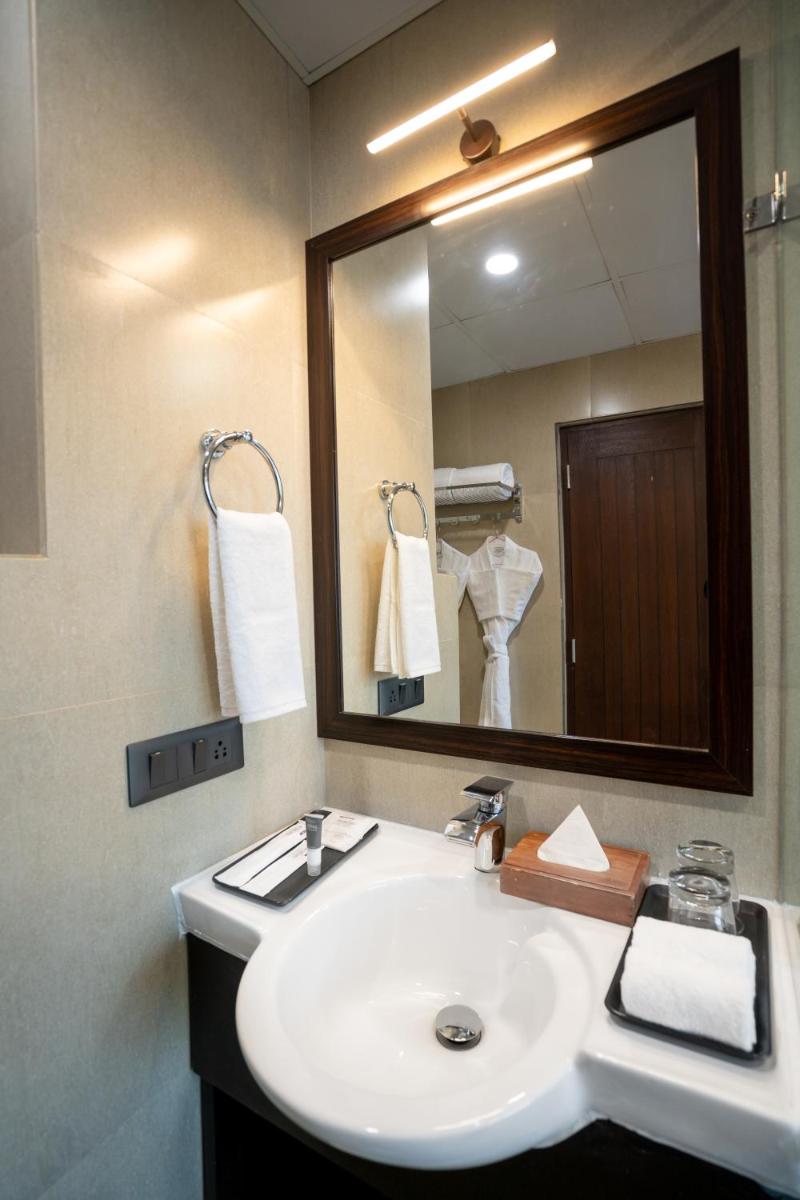 a bathroom with a sink and a mirror at The Orchid Shimla in Shimla