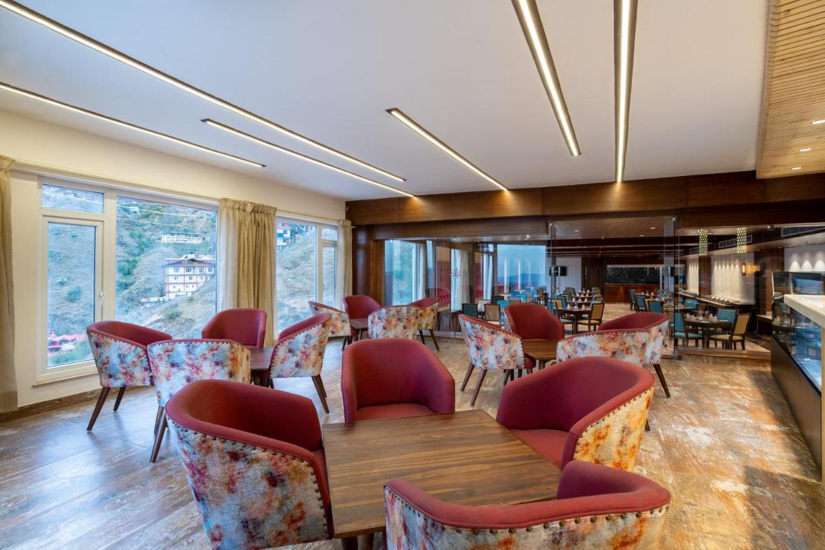 a dining room with a table and chairs at The Orchid Shimla in Shimla