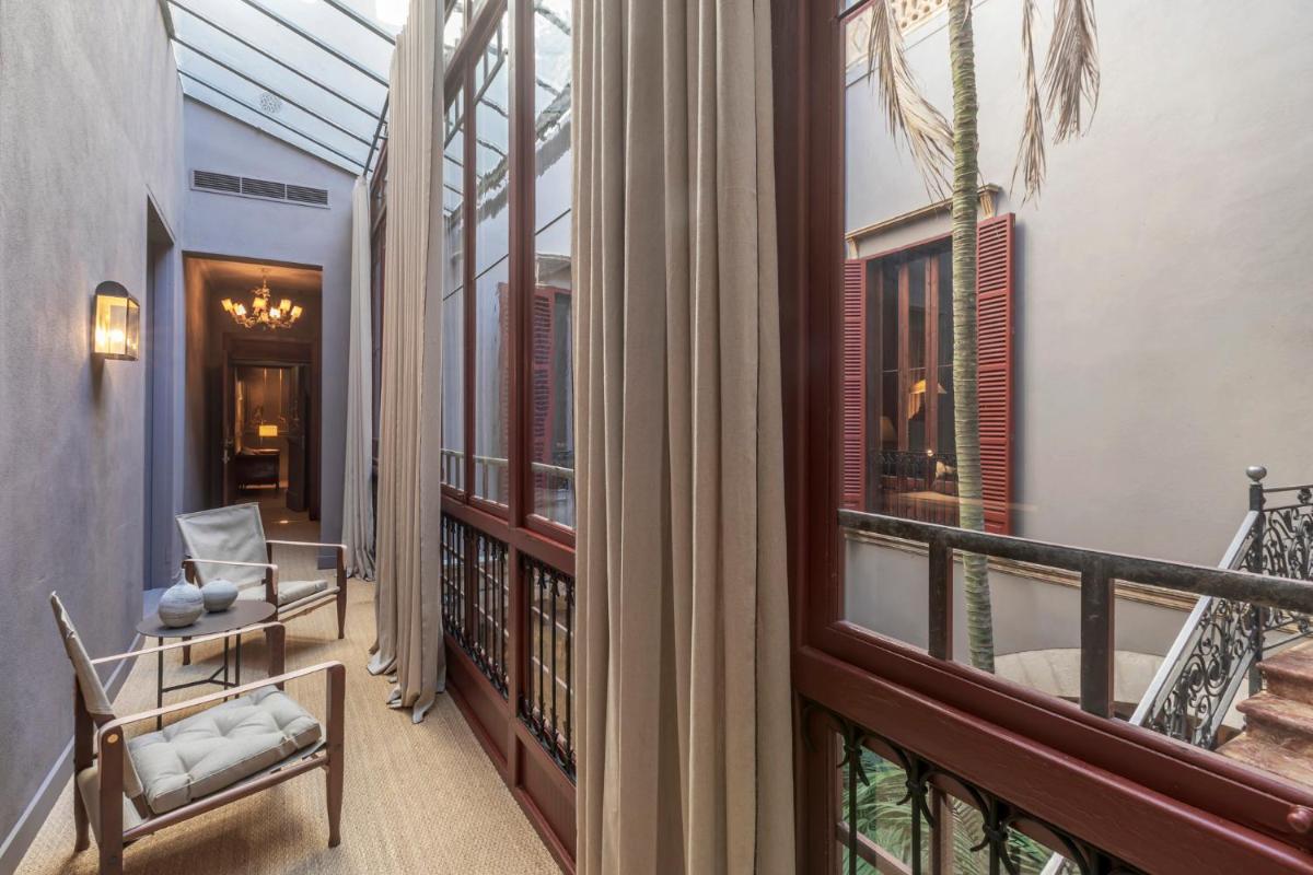 Una habitación con balcón con sillas y ventanas. en Hotel Can Cera, en Palma de Mallorca