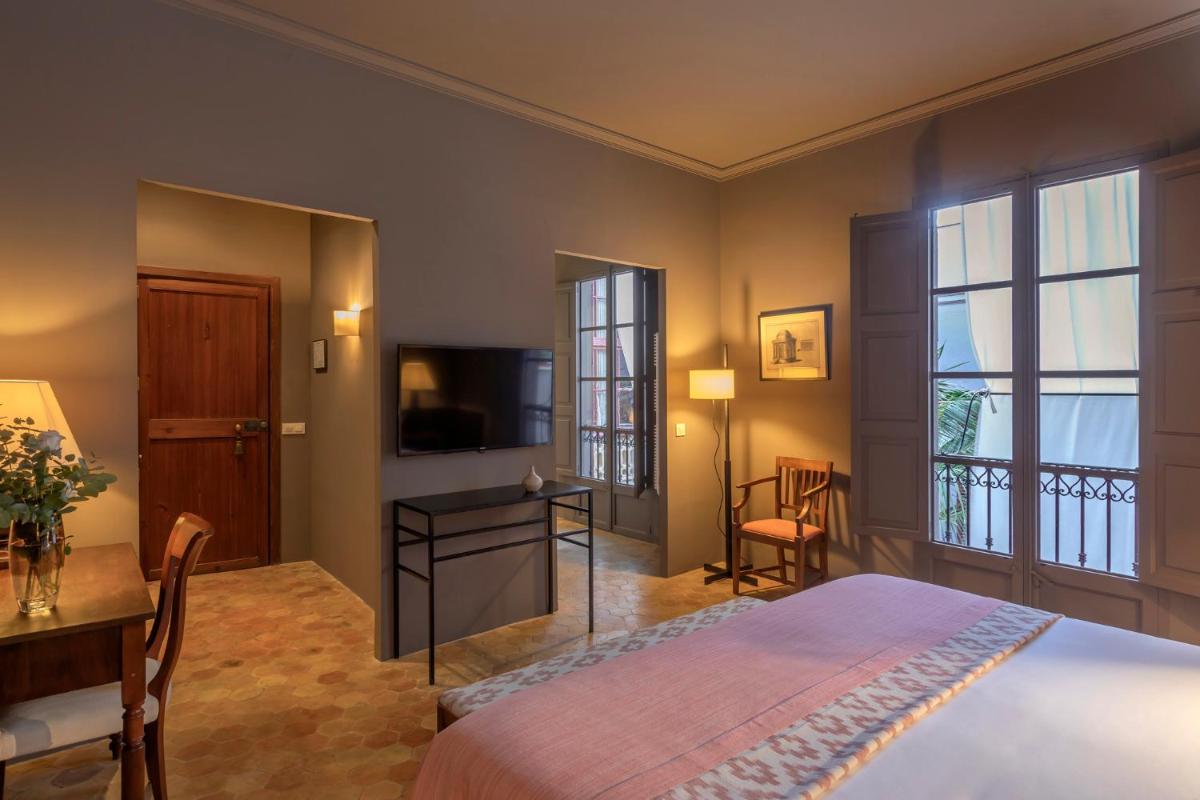 Un dormitorio con una cama, un escritorio y un televisor. en Hotel Can Cera, en Palma de Mallorca