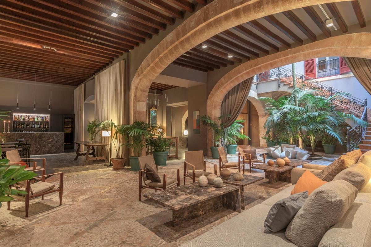 Una sala de estar con un sofá, mesas y sillas. en Hotel Can Cera, en Palma de Mallorca