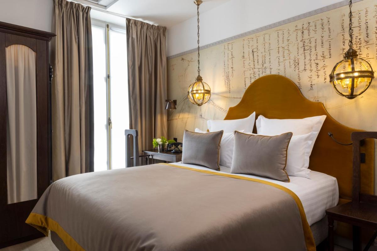 une chambre avec un grand lit blanc et deux oreillers dans l'établissement Hôtel & Spa Vinci Due, à Paris