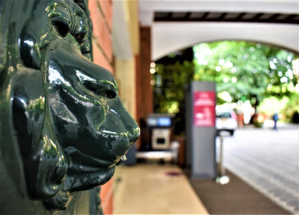 a green statue of a face on the side of a building at Hotel Royal Orchid Bangalore in Bengaluru