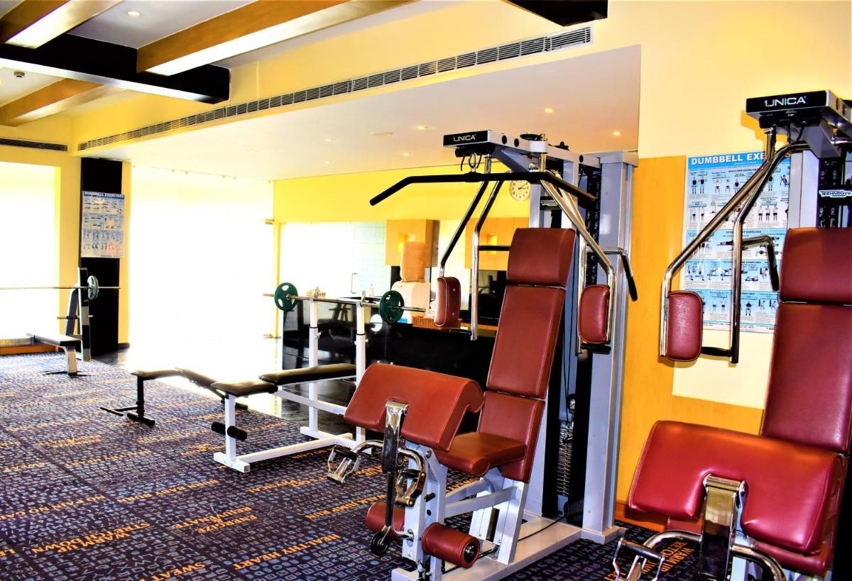 a gym with cardio equipment in a building at Hotel Royal Orchid Bangalore in Bengaluru
