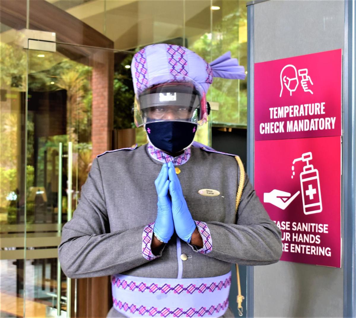 a man wearing a mask and a blue tie at Hotel Royal Orchid Bangalore in Bengaluru