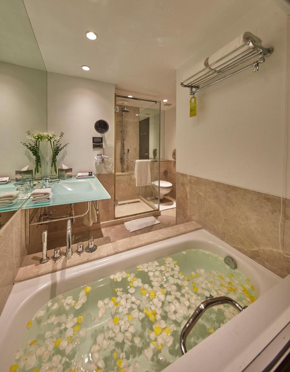 a bathroom with a bath tub filled with flowers at Hotel Royal Orchid Bangalore in Bengaluru
