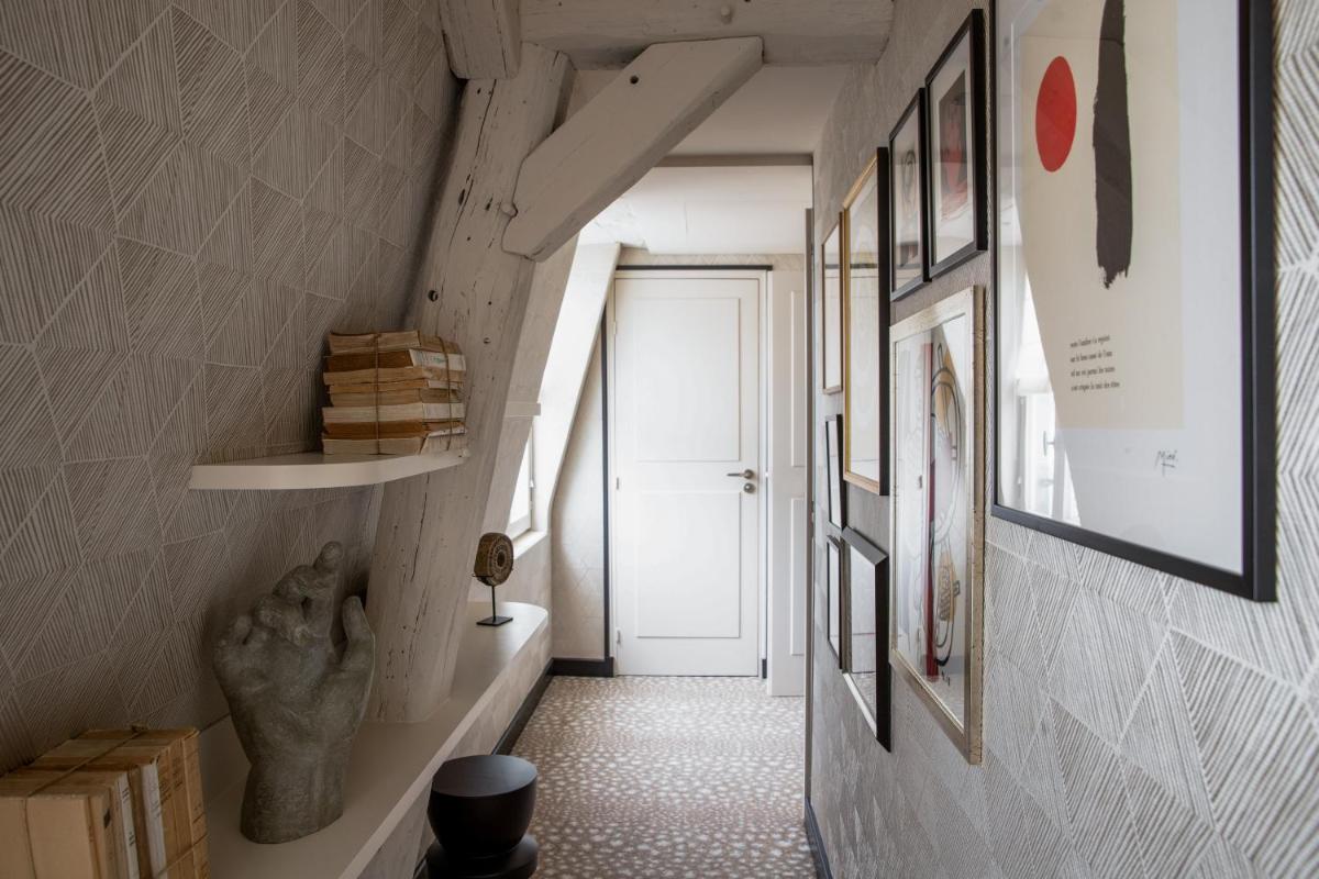 un couloir avec des photos sur le mur et une porte dans l'établissement Esprit Saint Germain, à Paris 51 autres photos
