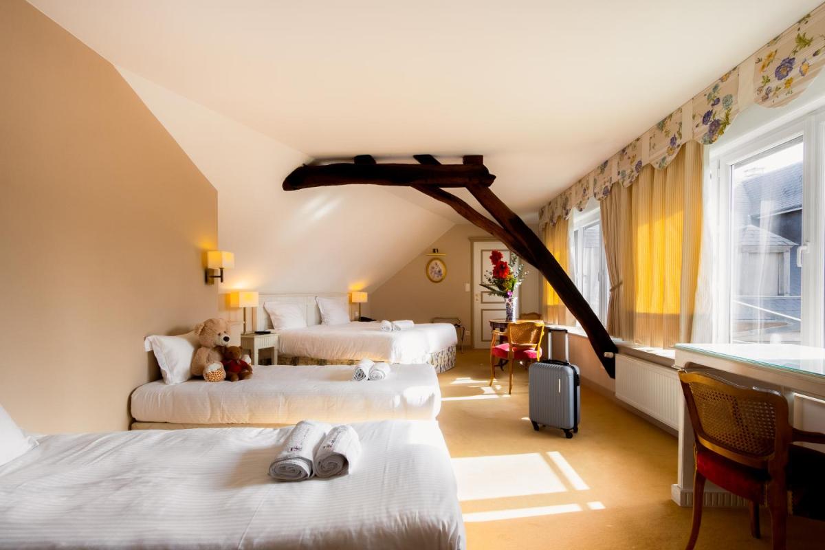 une chambre d'hôtel avec trois lits et une fenêtre dans l'établissement Mercure Moulins Centre Hôtel de Paris, à Moulins