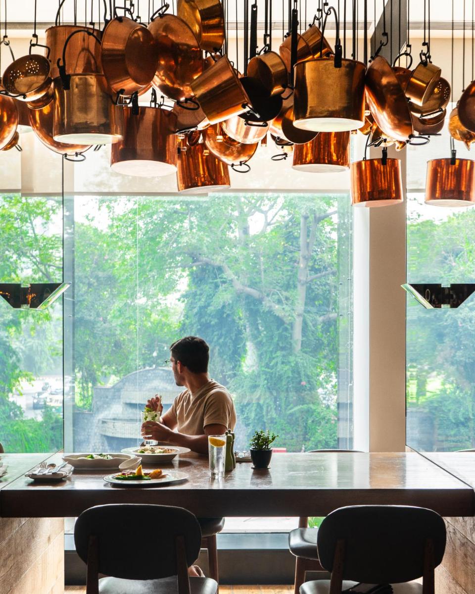 a man sitting at a table in front of a window at Shangri-La Eros New Delhi in New Delhi a man sitting at a table in front of a window at Shangri-La Eros New Delhi in New Delhi