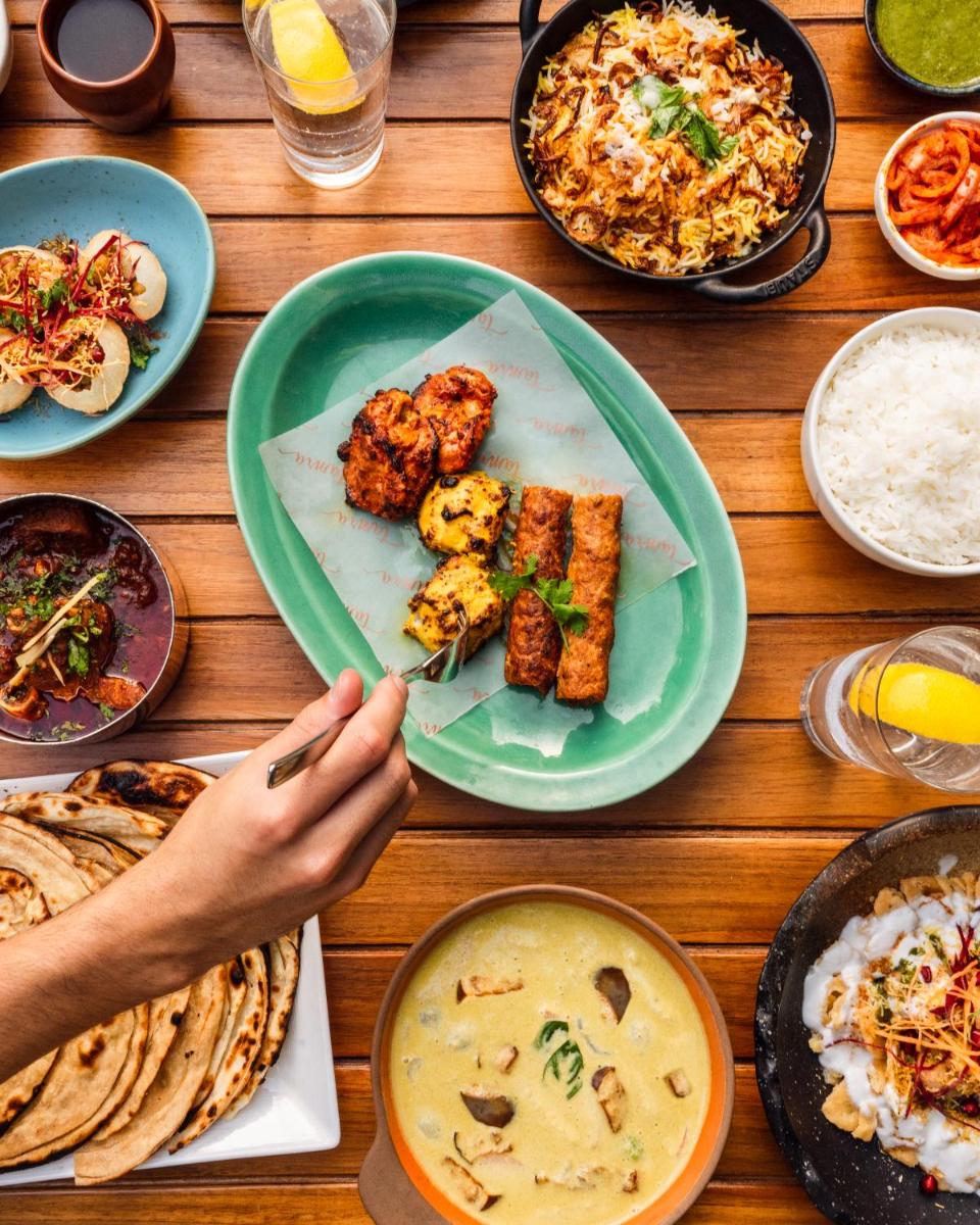 a wooden table with plates of food on it at Shangri-La Eros New Delhi in New Delhi a wooden table with plates of food on it at Shangri-La Eros New Delhi in New Delhi