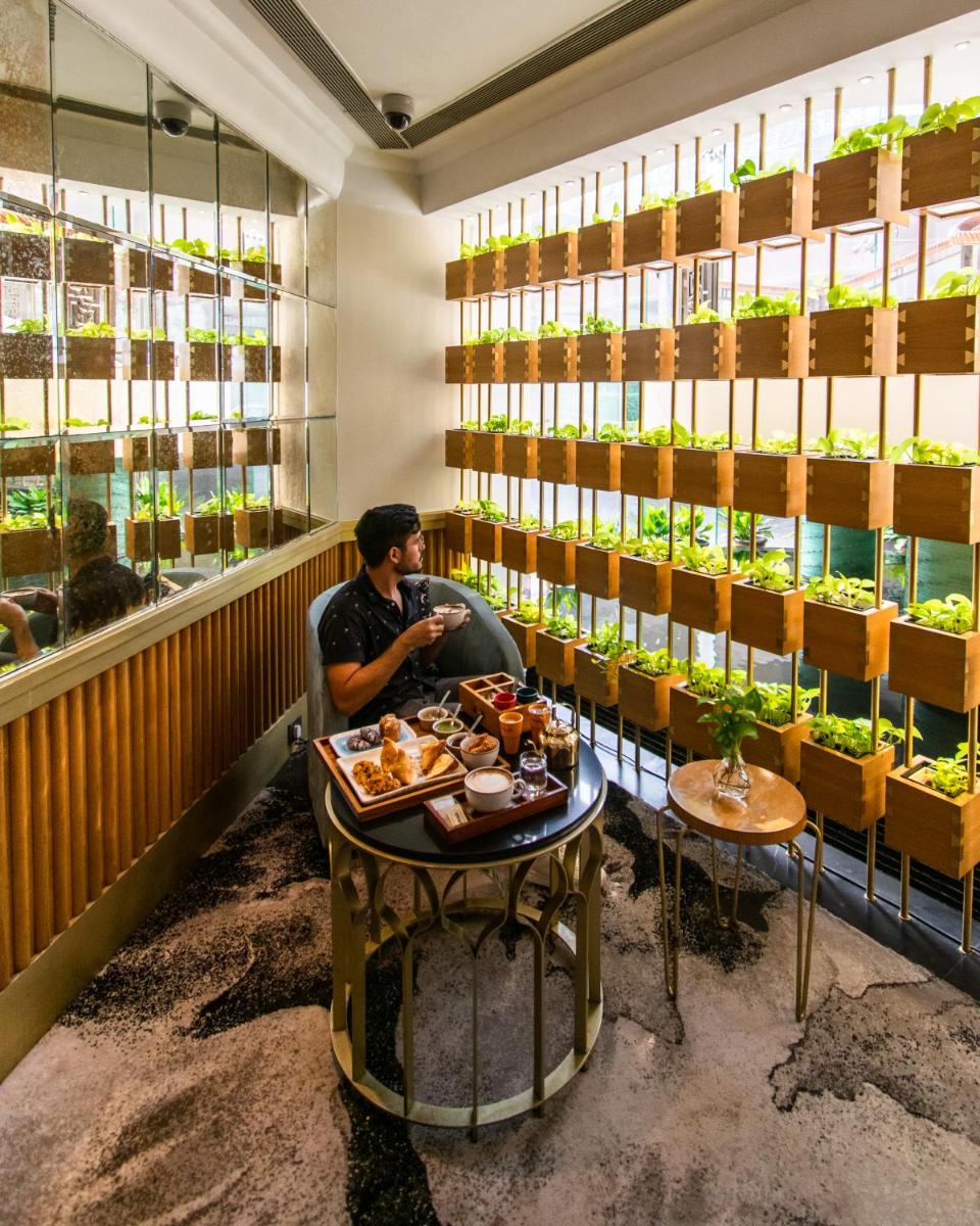 a man sitting at a table in a restaurant at Shangri-La Eros New Delhi in New Delhi a man sitting at a table in a restaurant at Shangri-La Eros New Delhi in New Delhi