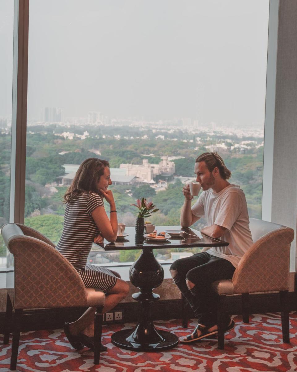a man and woman sitting at a table drinking coffee at Shangri-La Bengaluru in Bengaluru a man and woman sitting at a table drinking coffee at Shangri-La Bengaluru in Bengaluru