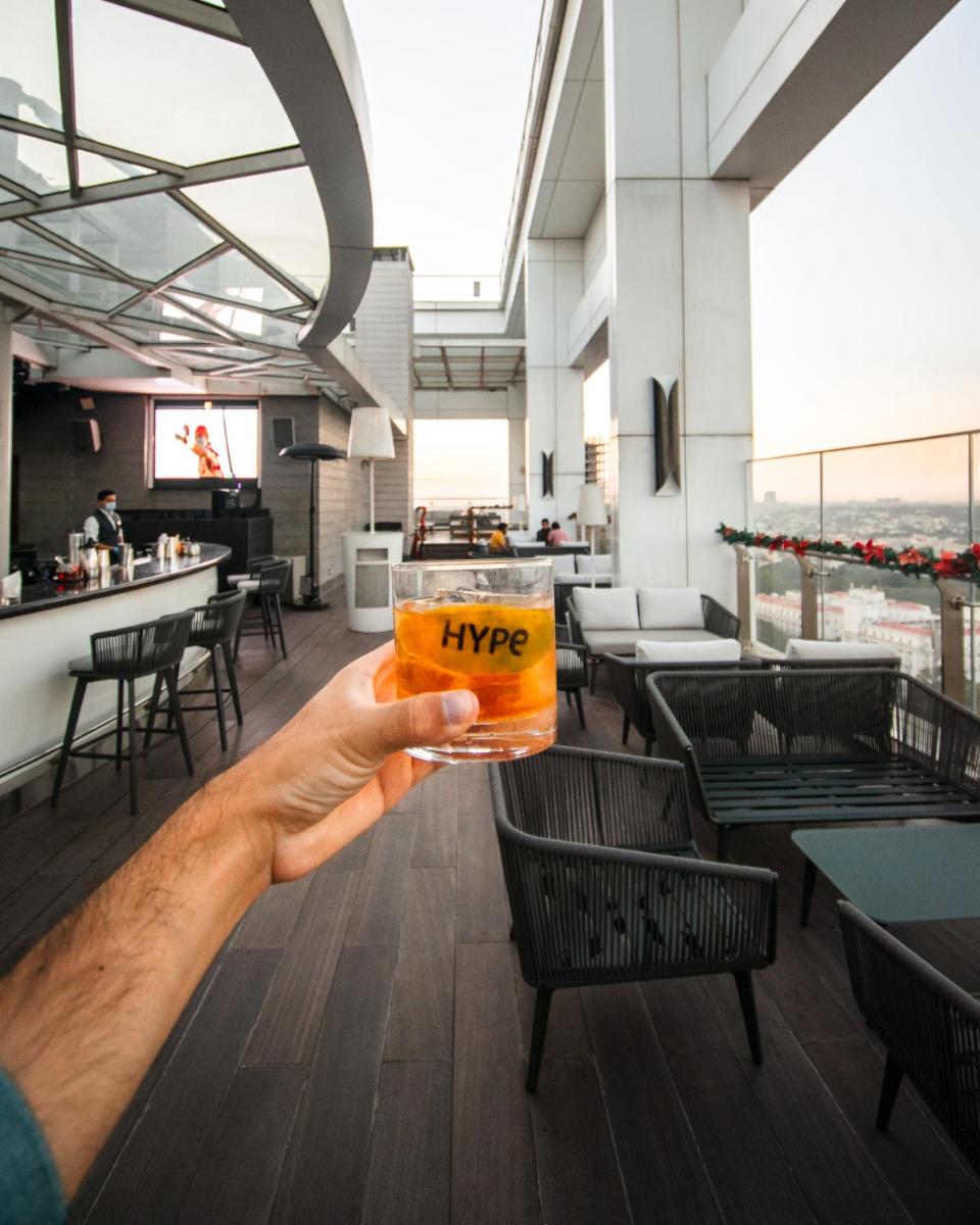 a person holding a glass of beer in a restaurant at Shangri-La Bengaluru in Bengaluru a person holding a glass of beer in a restaurant at Shangri-La Bengaluru in Bengaluru