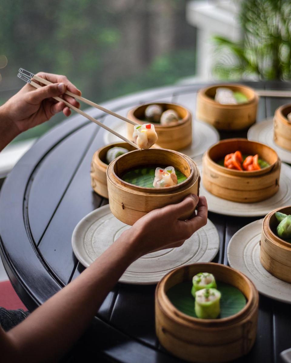 a person eating food in wooden bowls on a table at Shangri-La Bengaluru in Bengaluru a person eating food in wooden bowls on a table at Shangri-La Bengaluru in Bengaluru