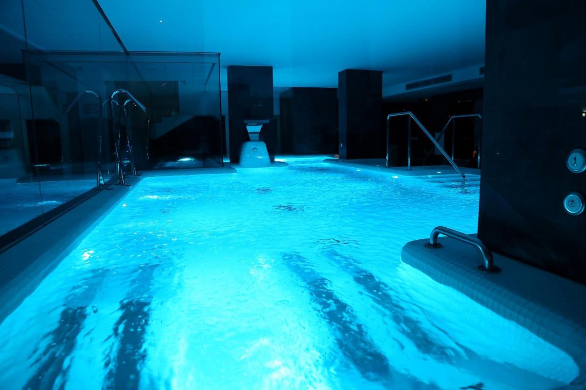 Una gran piscina con agua azul en un edificio. en Dña Monse Hotel Spa & Golf, en Torrevieja 62 fotos más