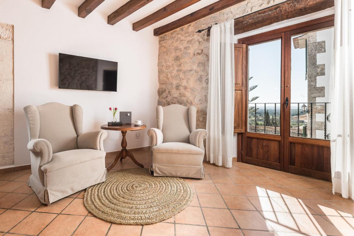 Una sala de estar con dos sillas y una mesa. en Ca'n Beneït, en Binibona