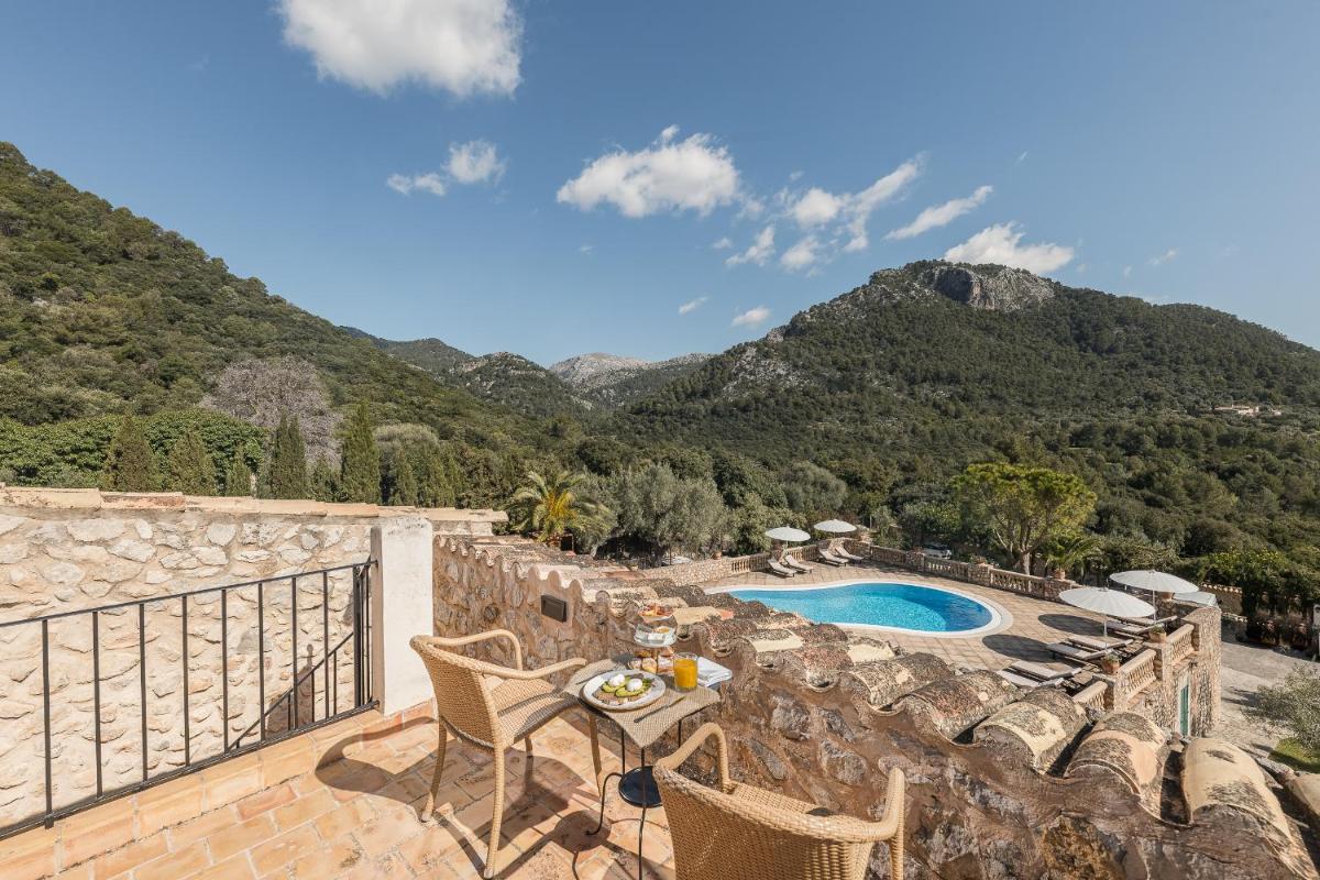 Un patio con mesa y sillas y una piscina. en Ca'n Beneït, en Binibona