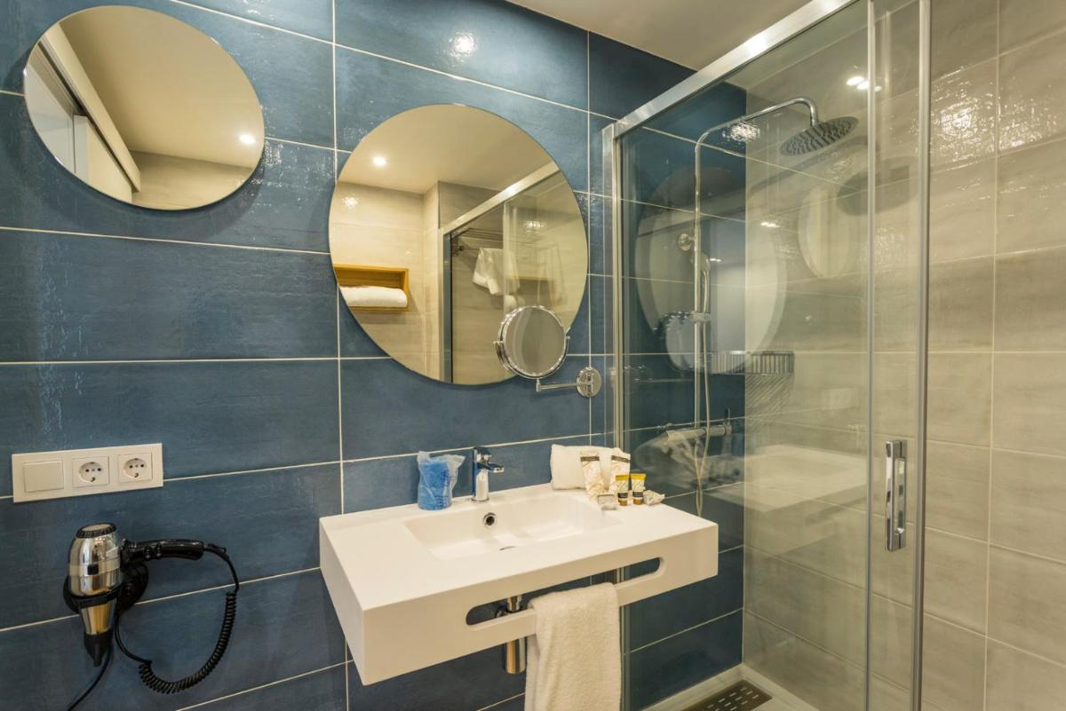 Un baño con lavabo, ducha y espejo. en Parque Nereida Suites Hotel, en Cala Ratjada