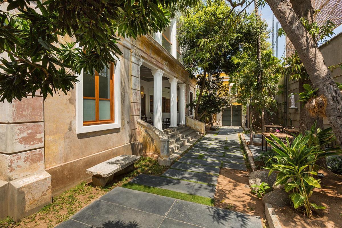 a house with a sidewalk next to a building at La Villa in Puducherry