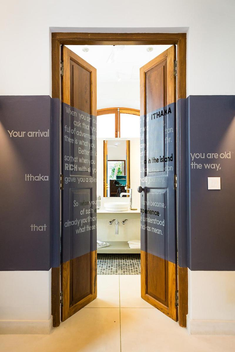 a room with an open door with a bathroom at La Villa in Puducherry