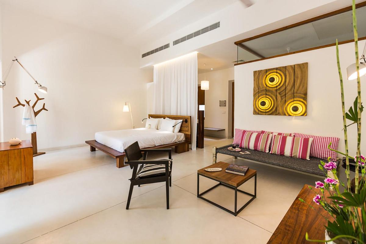 a hotel room with a bed and a couch at La Villa in Puducherry +42 photos