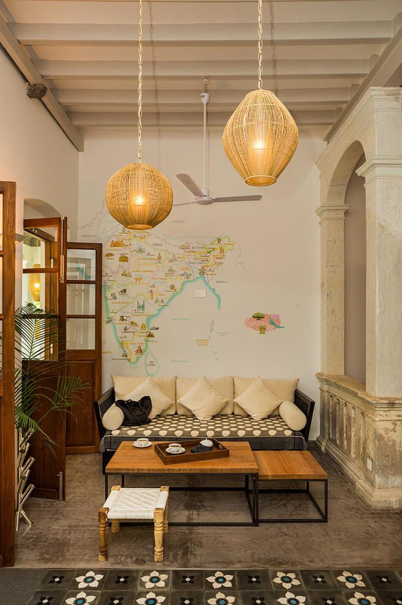 a living room with a couch and a map on the wall at La Villa in Puducherry