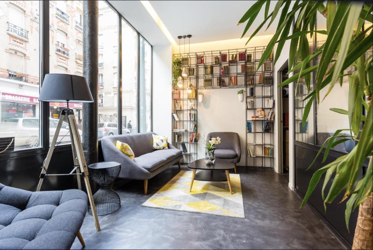 un salon avec un canapé, des fauteuils et une table dans l'établissement Atypik Hotel, à Clichy