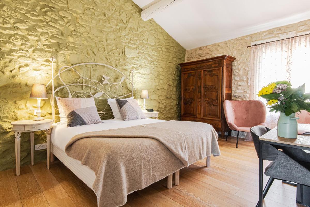 une chambre avec un grand lit dans une pièce dans l'établissement Hôtel Mas Valentine, à Saint-Rémy-de-Provence