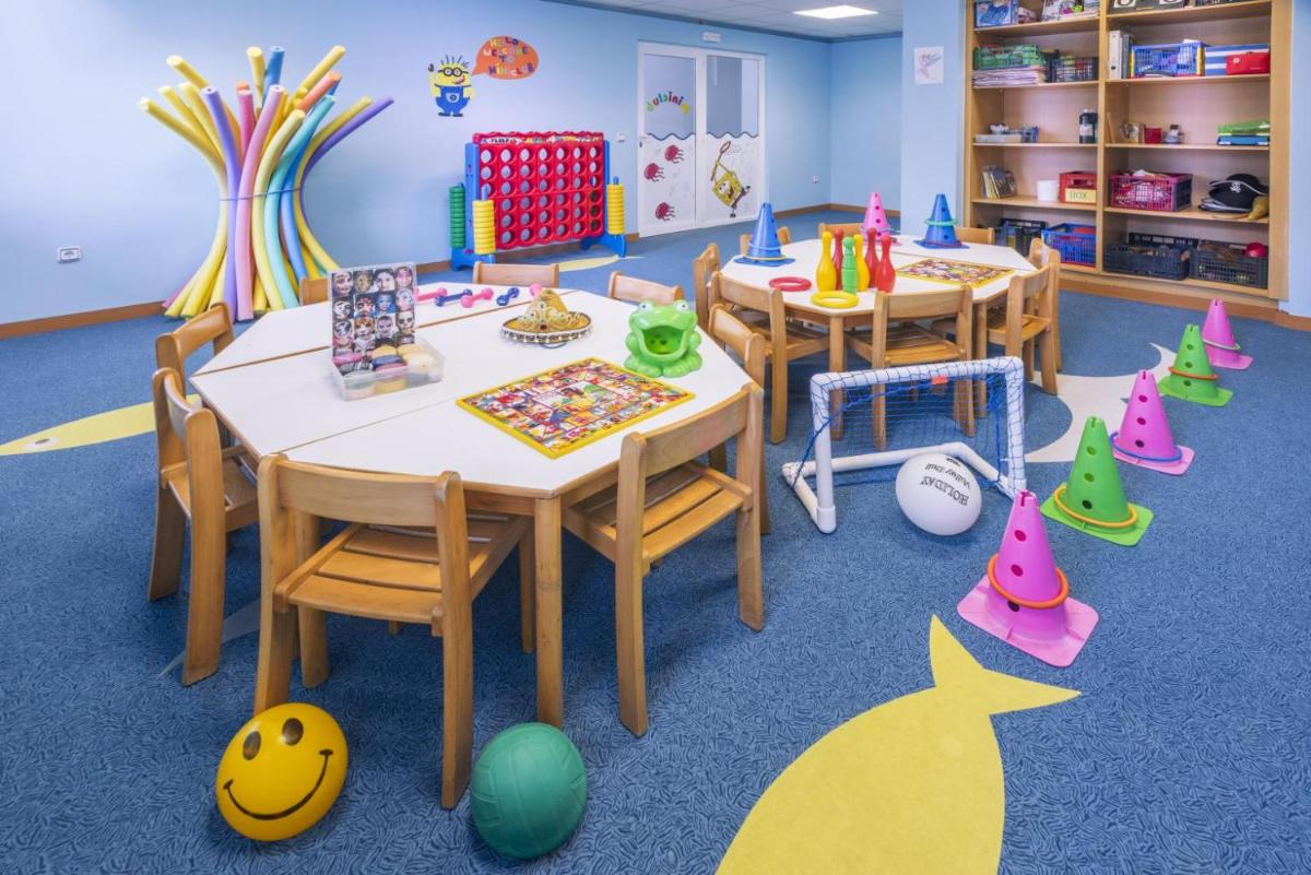 Un aula con dos mesas y sillas y juguetes. en Caprici Beach Hotel & Spa, en Santa Susanna