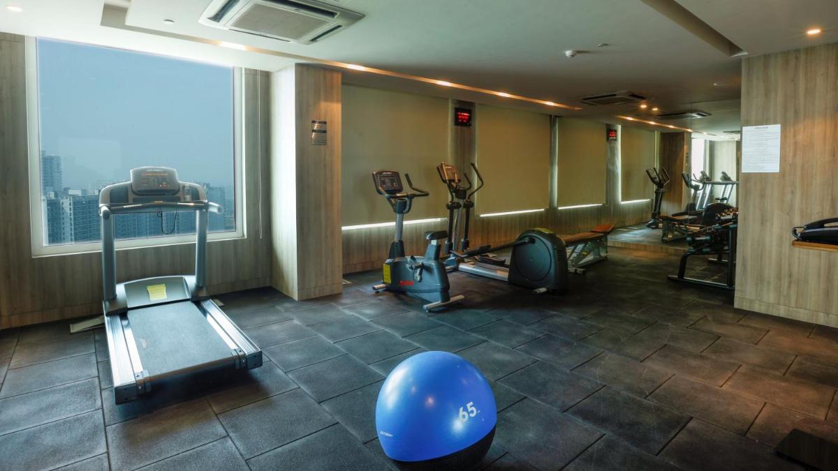 a gym with cardio equipment and a large window at Holiday Inn Gurugram Sector 90 by IHG in Gurgaon