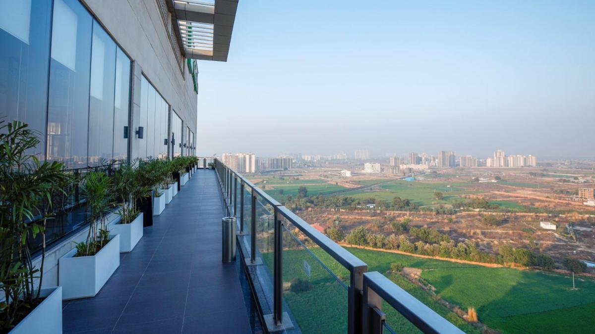a balcony of a building with a view of a city at Holiday Inn Gurugram Sector 90 by IHG in Gurgaon