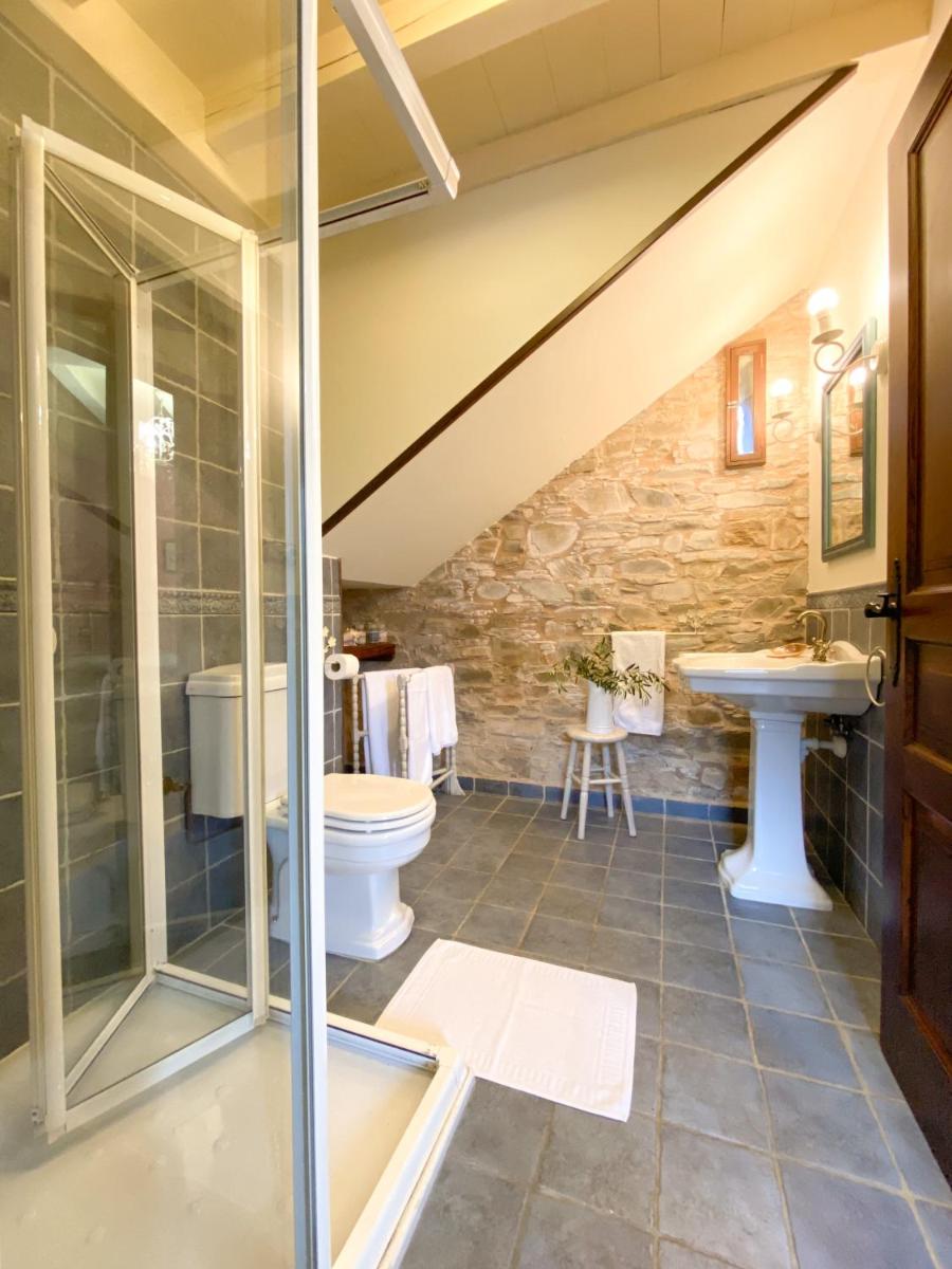 un baño con inodoro y lavabo en Hotel Casa Cachón, en Tol