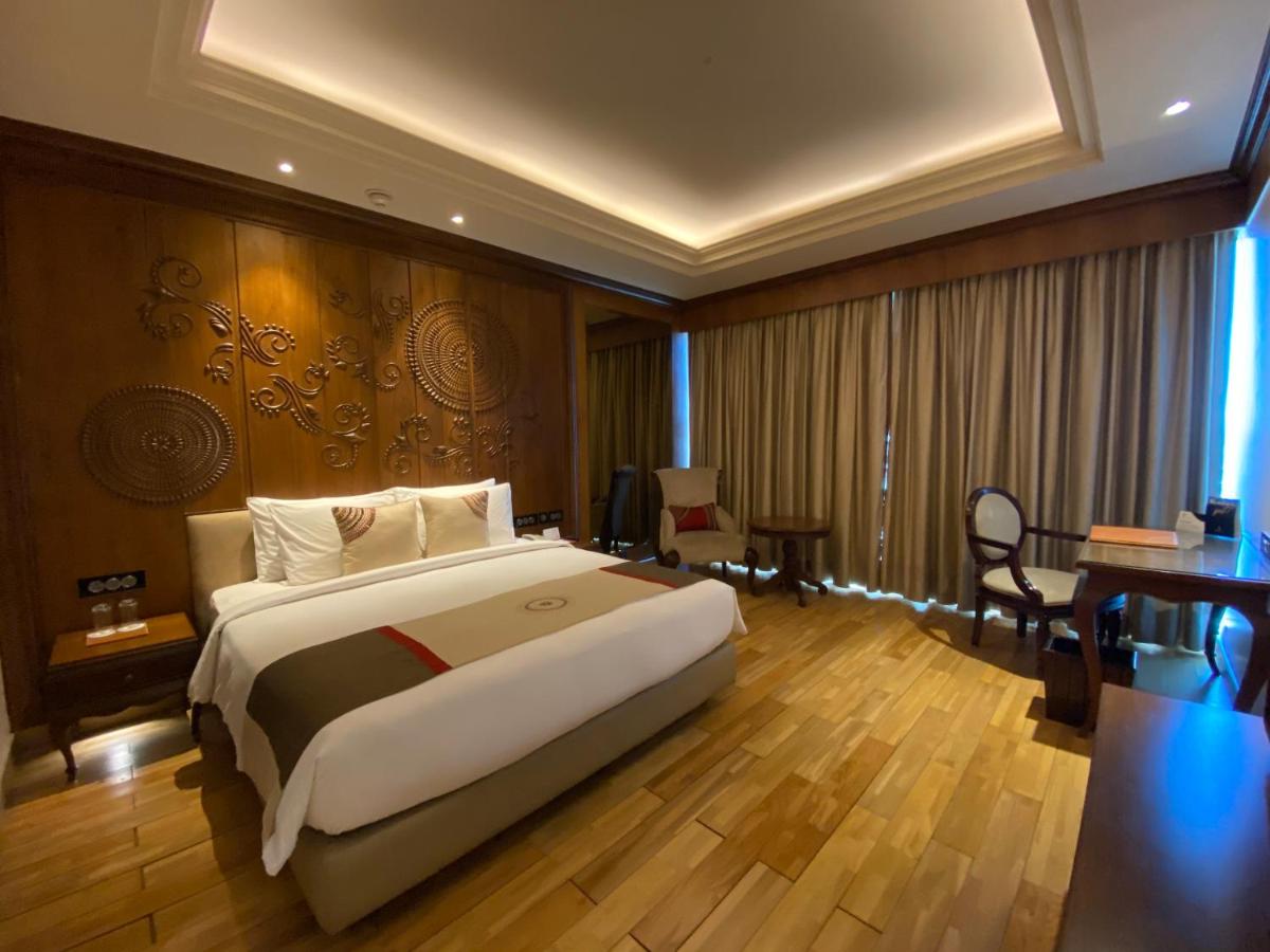 a hotel room with a large bed and a desk at Seven Seas Hotel in New Delhi
