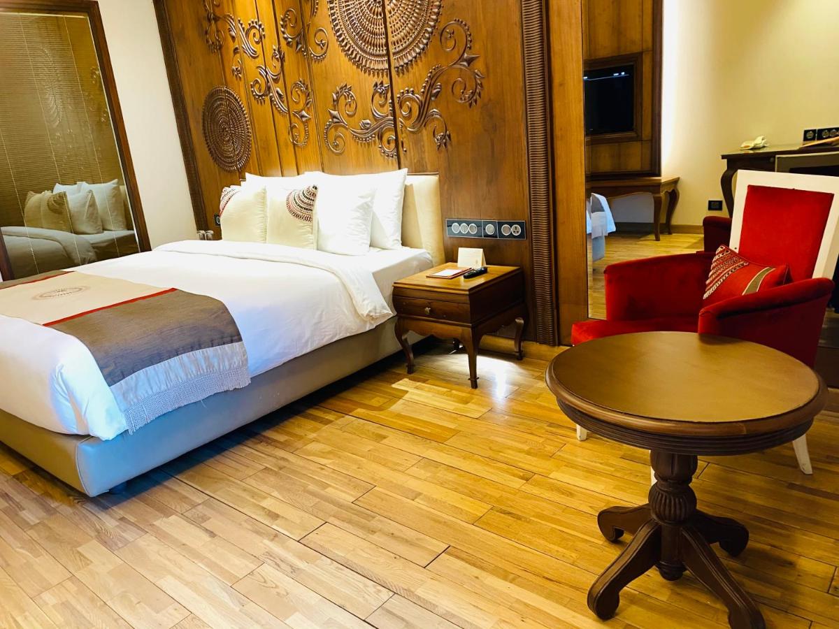 a hotel room with a bed and a table and a chair at Seven Seas Hotel in New Delhi