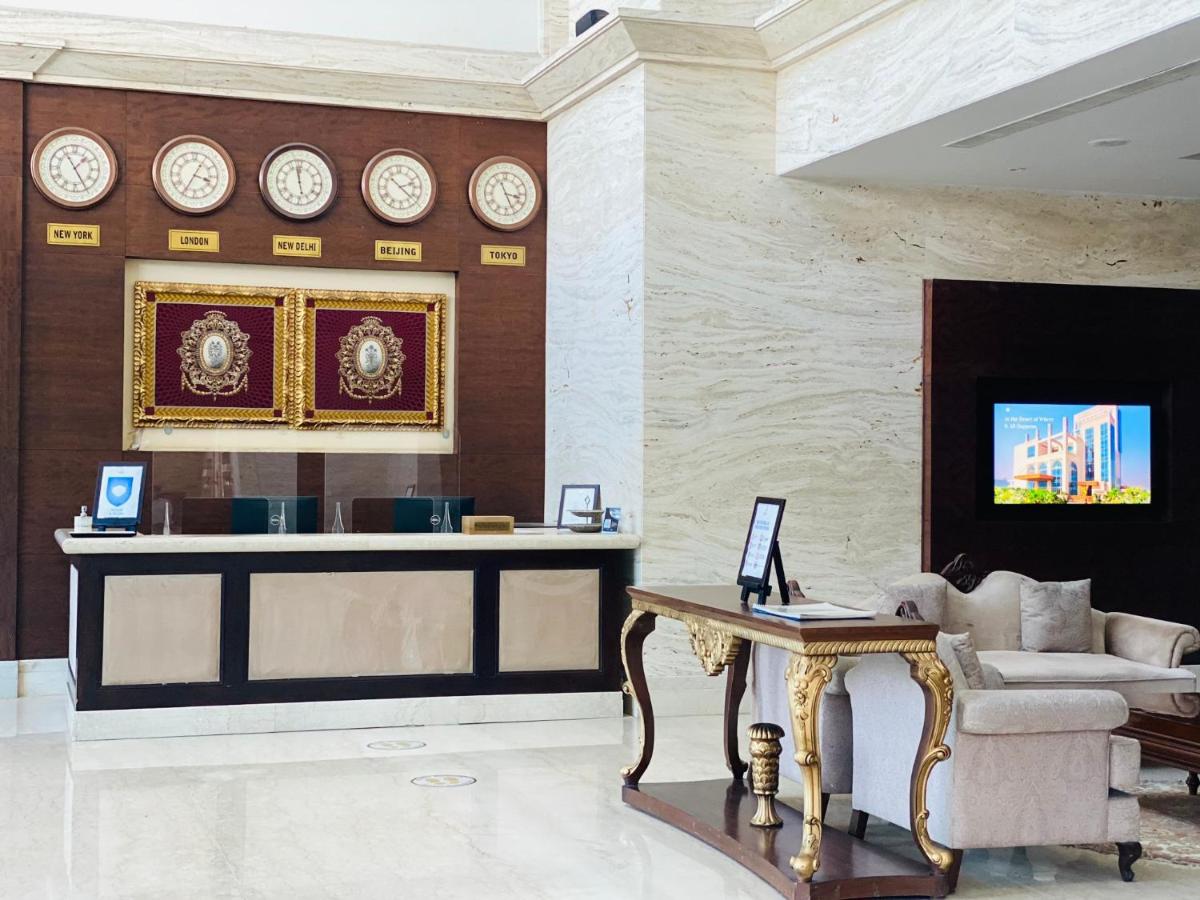 a living room with a couch and clocks on the wall at Seven Seas Hotel in New Delhi
