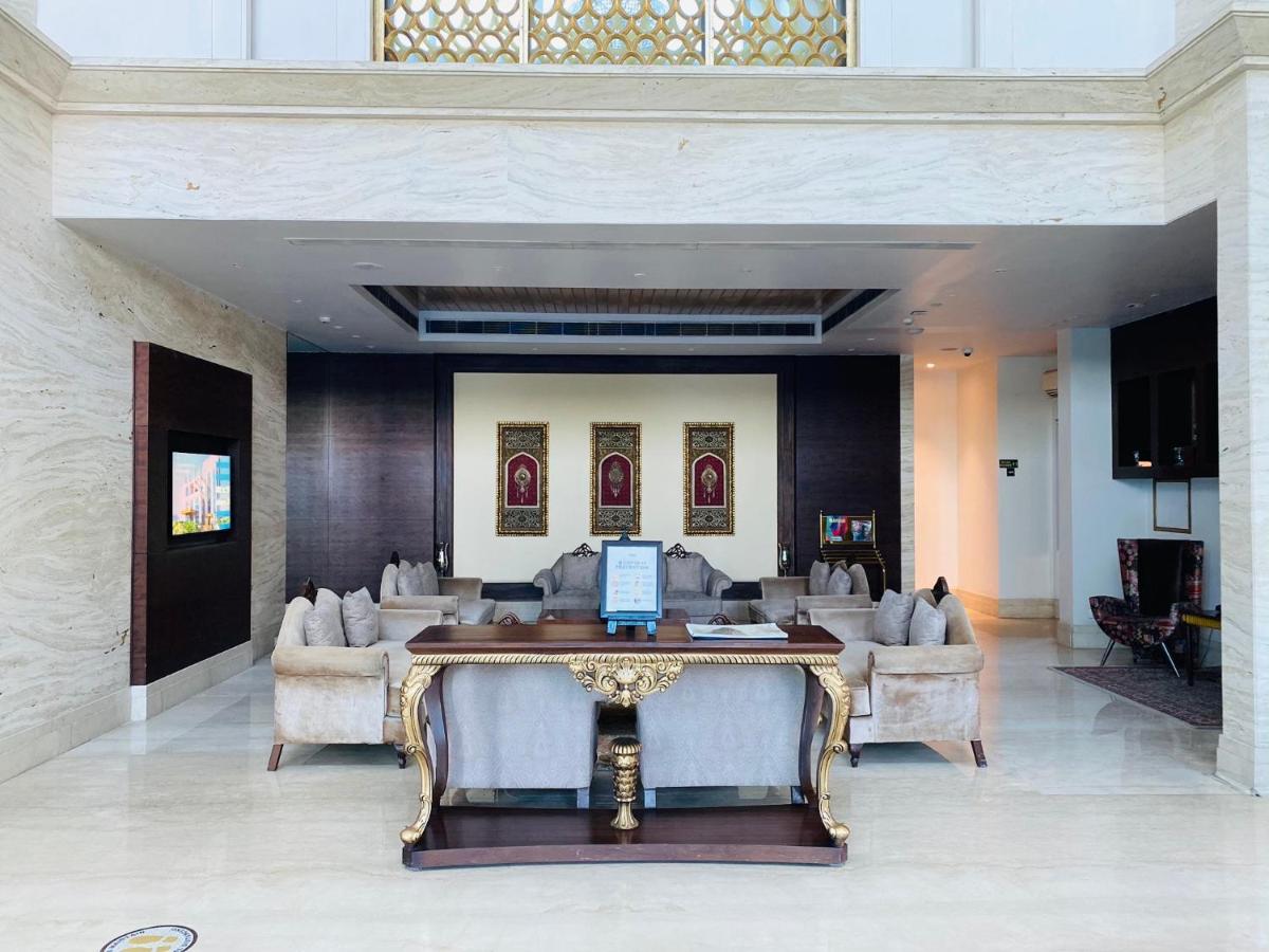 a lobby with a table and couches in a building at Seven Seas Hotel in New Delhi