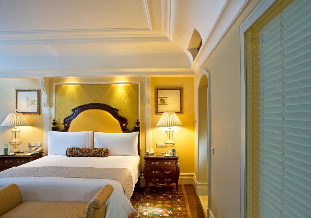 a bedroom with a king sized bed and a couch at The Leela Palace Bengaluru in Bengaluru a bedroom with a king sized bed and a couch at The Leela Palace Bengaluru in Bengaluru