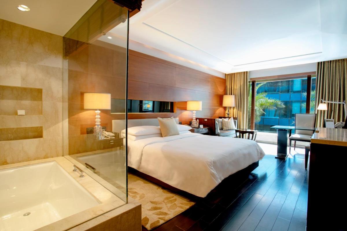 a hotel room with a bed and a bath tub at The Leela Ambience Gurugram Hotel & Residences - The Luxury Urban Sanctuary in Gurgaon