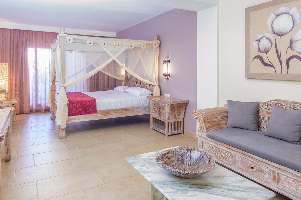 Un dormitorio con una cama y un sofá en una habitación. en El Cortijo de Zahara by QHotels, en Zahara de los Atunes 69 fotos más