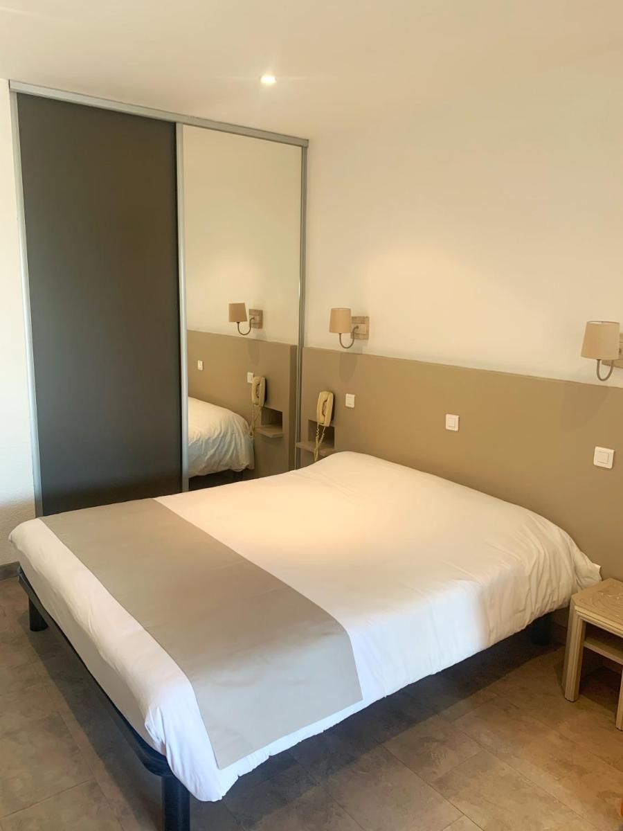 Un ou plusieurs lits dans un hébergement de l'établissement Hôtel Beau Soleil