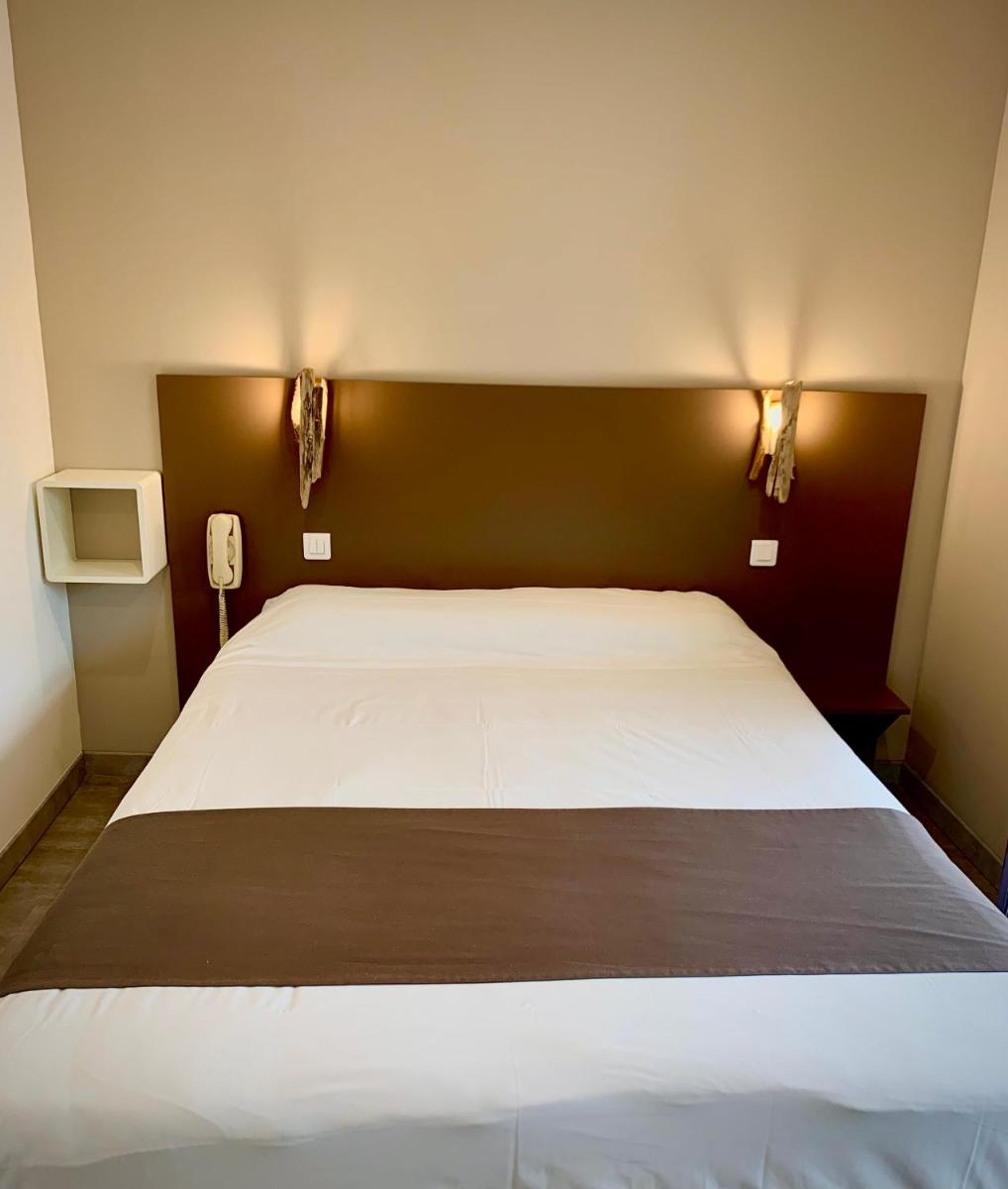 Un ou plusieurs lits dans un hébergement de l'établissement Hôtel Beau Soleil