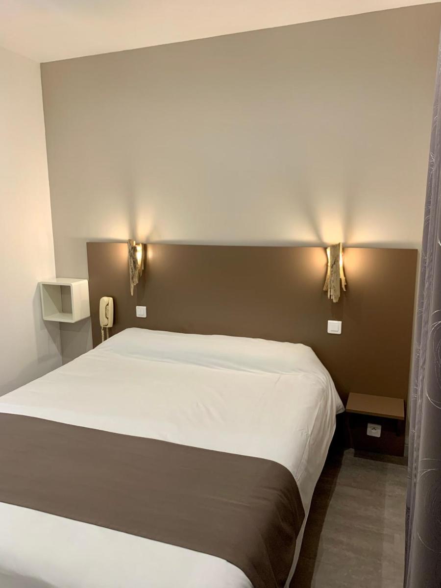 Un ou plusieurs lits dans un hébergement de l'établissement Hôtel Beau Soleil
