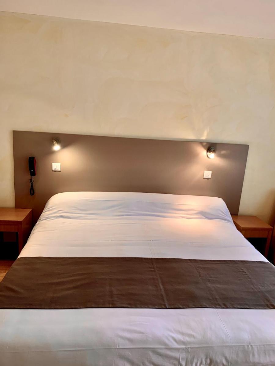 Un ou plusieurs lits dans un hébergement de l'établissement Hôtel Beau Soleil