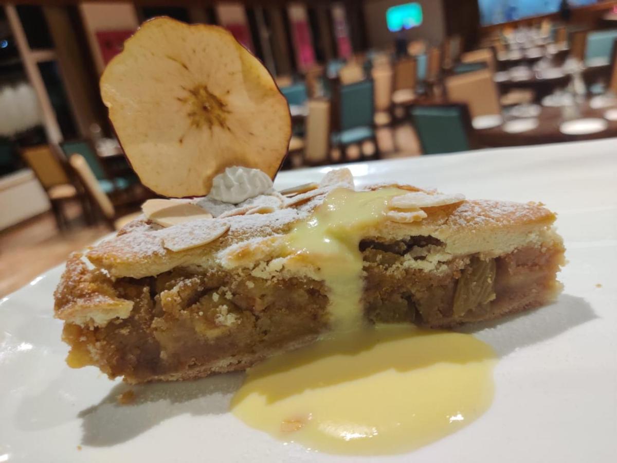 a piece of cake on a white plate with a banana at The Orchid Shimla in Shimla